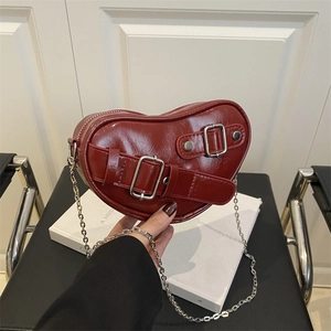 Glossy red heart-shaped shoulder bag with silver chain and vintage buckle straps