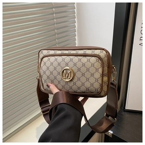 Close-up of vintage brown monogram crossbody bag with gold metal logo and wide strap