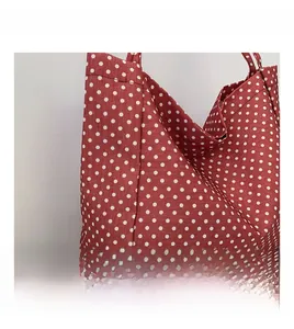 Detail of red canvas tote bag with white polka dots showing fabric texture and large capacity
