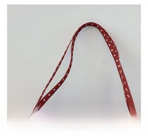 Detail of red and white polka dot tote bag handle with high-quality white stitching