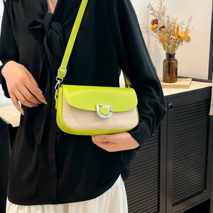 Chic lime green and beige woven crossbody bag with metallic D-lock shown on a model