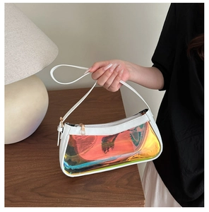 Macro detail of iridescent laser handbag with white trim and golden zipper on wooden table
