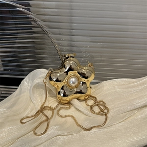 Golden star-shaped evening clutch bag with pearl detail and snake chain strap