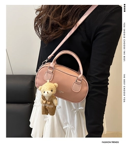 Pink lychee texture crossbody bag with cute teddy bear charm shown on a model