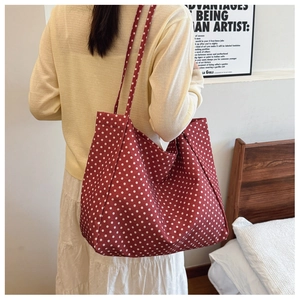 Close-up of red canvas tote bag with white polka dots showing large capacity shoulder strap