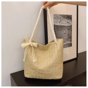 Detailed texture of beige woven straw bag with white rope handles and lace bow decoration