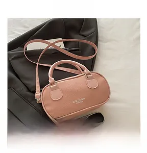 Detailed shot of pink pebble texture leather crossbody bag on grey blazer and white linen