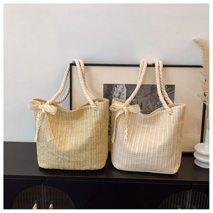 Detailed close-up of woven straw tote bags featuring cotton rope handles and lace bow accents
