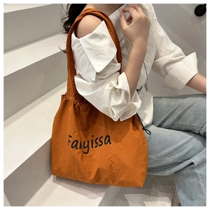 Detail of orange nylon tote bag with drawstring side and Fanyissa letter print