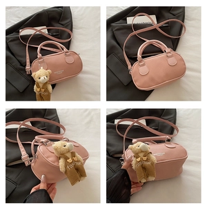 Detail of pink lychee leather bowling bag with cute teddy bear charm and strap