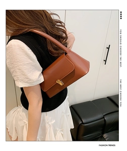 Vue détaillée d'un sac hobo vintage en cuir marron avec fermoir doré et bandoulière d'épaule