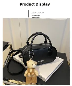 Close-up of black lychee texture bowling bag with white lettering and cute bear charm