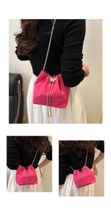 Detail of fuchsia pleated bucket bag with silver butterfly clasp and pearl charms