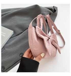 Detail of a pink washed fabric bag featuring a large bow and crinkled texture
