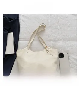 Detail of off-white tote bag showing natural pleated texture and adjustable gold buckle