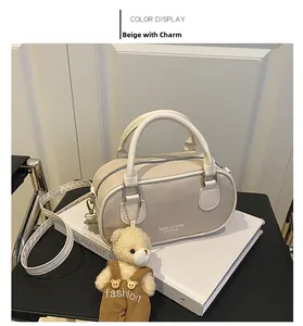Detail of beige bowling shoulder bag with plush bear charm and soft leather texture