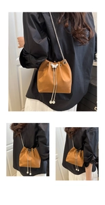 Detail of crocodile pattern bucket bag featuring butterfly clasp and pearl drawstring