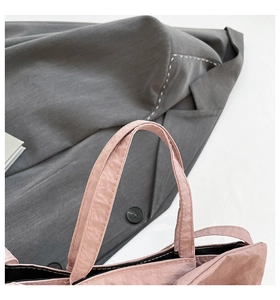 Detail of pink bow tote bag showing soft pleated texture and reinforced double stitching