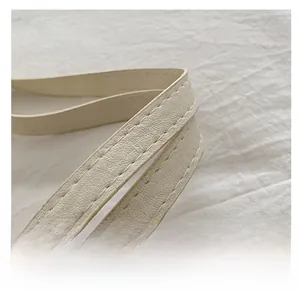 Macro shot of minimalist cream white leather strap with reinforced stitching details