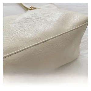 Close-up of cream soft leather tote bag with lychee texture and precision stitching