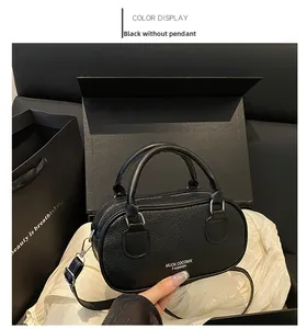 Detail of black pebbled leather mini bowling bag in a premium gift box presentation