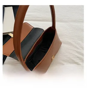 Vue détaillée du sac baguette en cuir marron avec boucle métallique et doublure en tissu