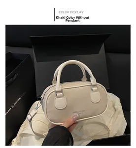 Detail of khaki pebbled leather bowling bag in black gift box with detachable strap