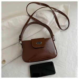 Macro view of brown glossy mini shoulder bag with JWHN logo and size reference