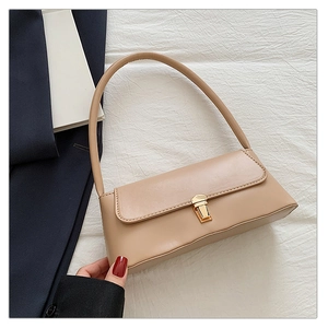 Détail du sac baguette en cuir beige avec fermoir métallique doré et texture lisse élégante
