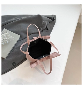 Detailed close-up of a pink bow tote bag featuring a secure magnetic metal clasp closure