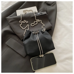Détail du sac seau noir motif crocodile avec chaîne argentée et pendentifs perles