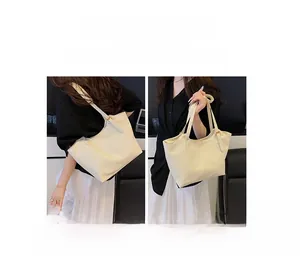 Detail view of cream soft leather tote bag with adjustable straps for shoulder or hand carry