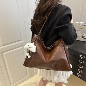 Grand cabas marron en similicuir avec charm nuage blanc porté par un mannequin
