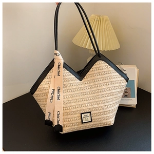 Macro detail of woven straw tote bag featuring black PU straps and Sport Fashion label