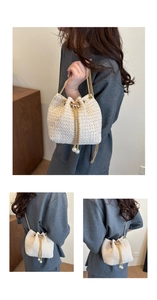 Detail of woven beige bucket bag with pearl drawstring and golden chain strap