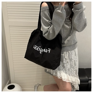 Detailed view of large black canvas tote bag with Fanyiss logo and drawstring closure