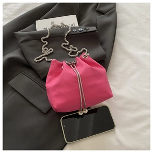 Détail du sac seau rose fuchsia à texture crocodile avec cordon perle et chaîne argent