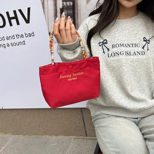 Cute red canvas handbag with colorful woven handle and yellow embroidery text