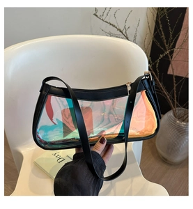 Detailed shot of a holographic jelly shoulder bag with black trim on a modern white chair