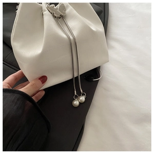 Détail du sac seau blanc à motif crocodile avec fermoir papillon argenté et perles