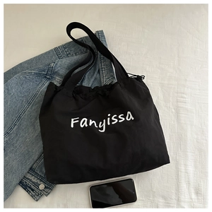 Detail view of the drawstring closure and white Fanyissa lettering on the black canvas tote
