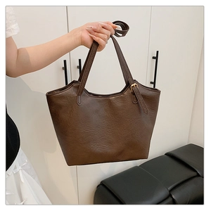 Dettaglio della borsa tote marrone scuro in pelle sintetica con fibbia in metallo dorato