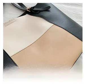 Detail of multi-color paneled tote bag featuring adjustable strap and golden hardware