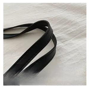 Close-up of black leather tote bag handle showing high-quality stitching and texture