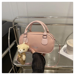 Close-up of pink lychee grain PU leather bowling bag with cute white bear plush charm