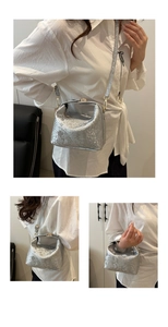 Detail of silver embossed faux leather crossbody bag with golden hardware and textured surface