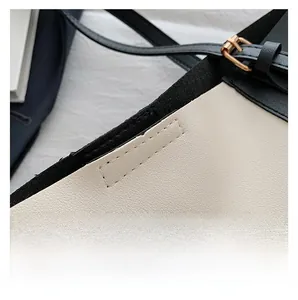 Detail showing the neat stitching and textured leather finish on a contrast tote bag