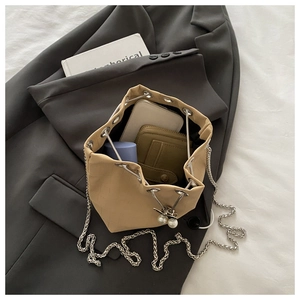 Vue intérieure du sac seau tissé beige montrant l'espace pour téléphone et maquillage