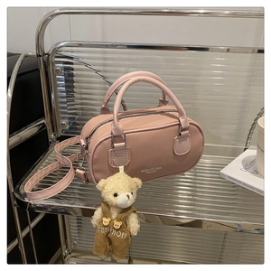 Detail of pink lychee leather bowling bag with silver zipper and cute bear charm