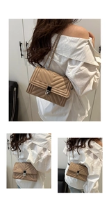 Close-up of beige quilted crossbody bag featuring V-shaped texture and metal lock